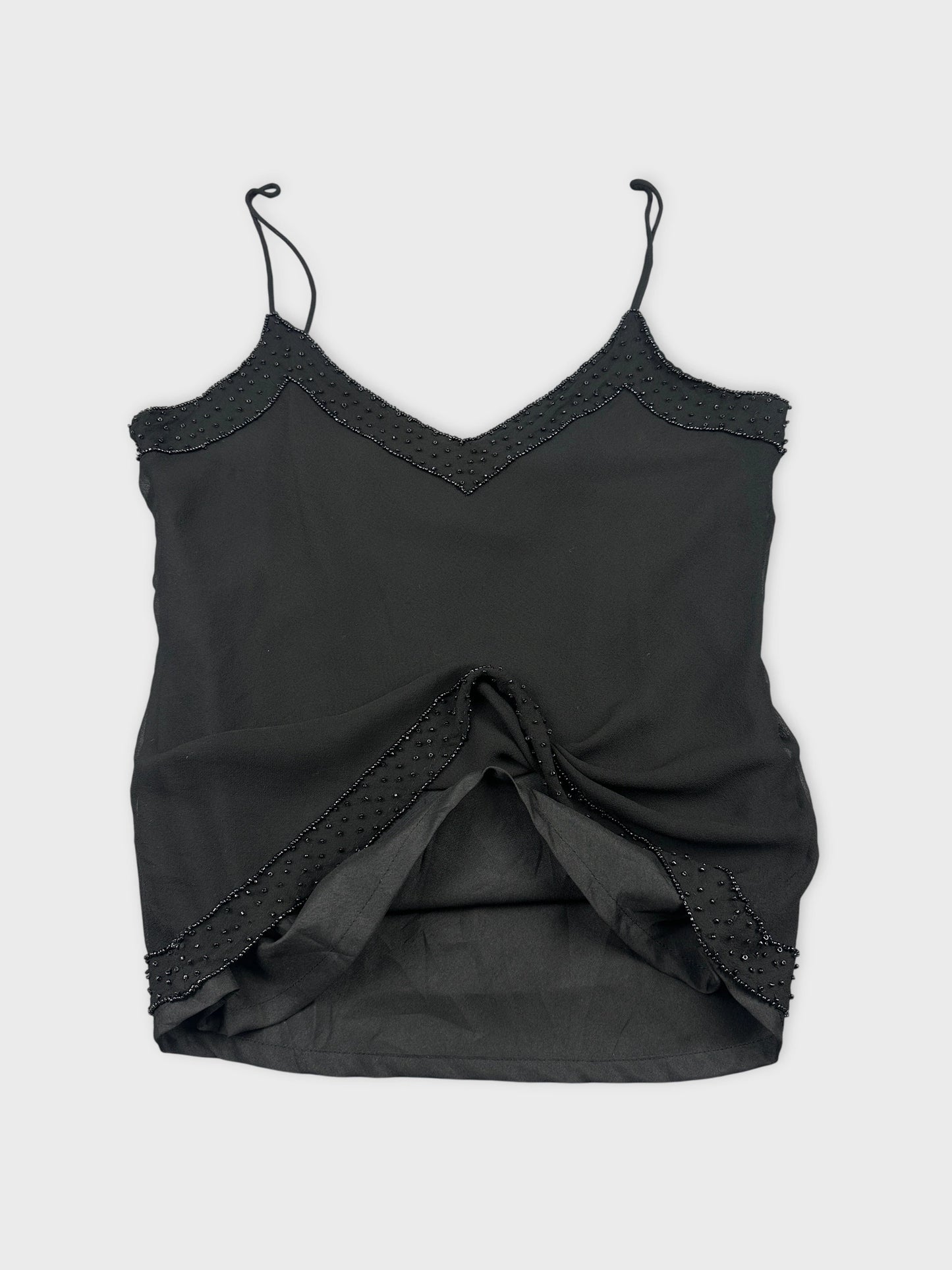 Detail view of a black camisole top with beaded trim.