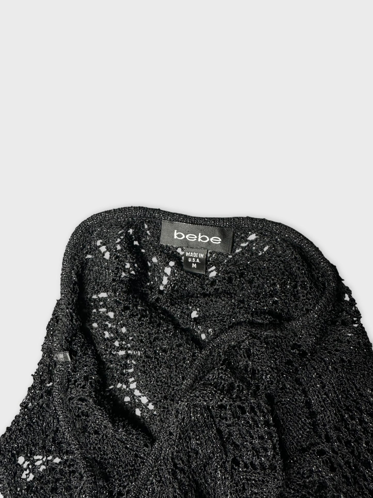 Detail view of a black short sleeve top with lace texture.