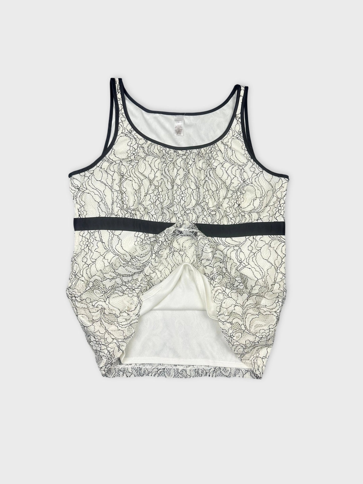 detail view of a sleeveless white lace top with black trim