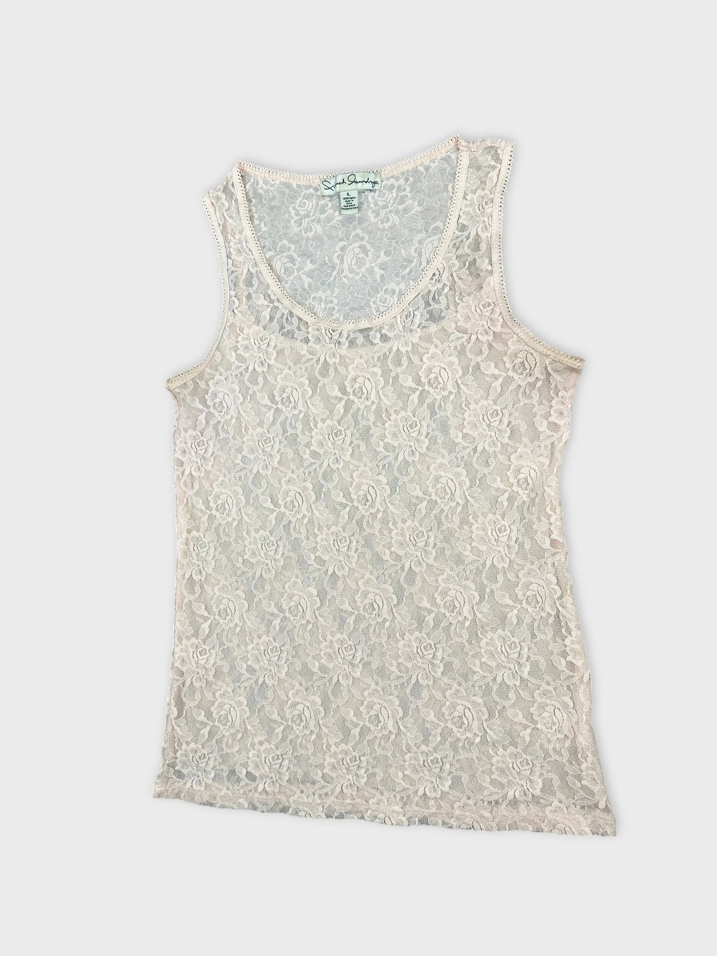 Detail view of a light pink lace tank top with floral pattern.