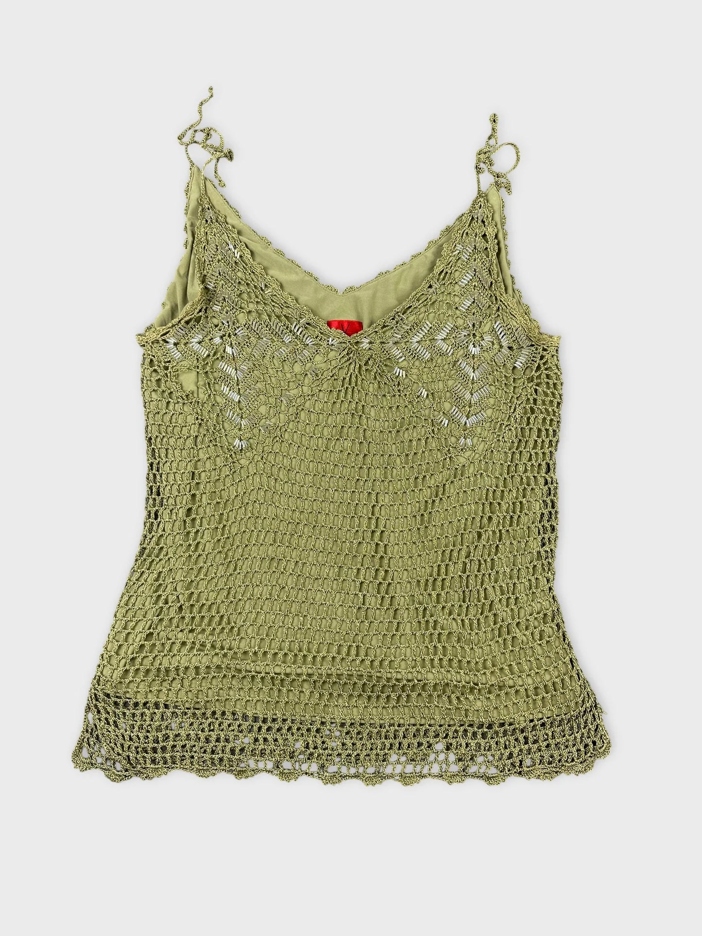 Front view of a light green crochet top with lace hem.