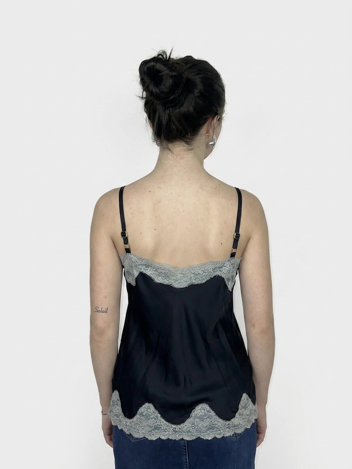 Black women’s top with lace trim, back view revealing adjustable straps.