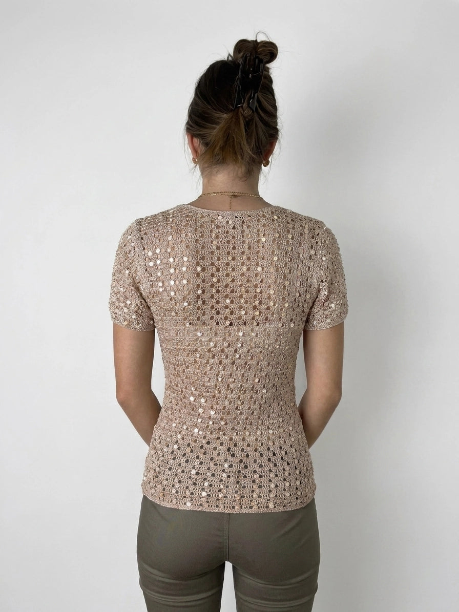Back view of a short-sleeved top in light pink with a lattice pattern.