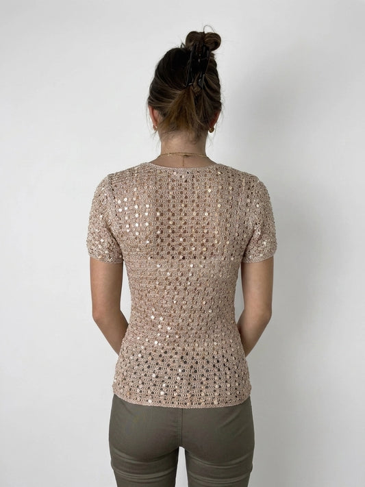 Back view of a short-sleeved top in light pink with a lattice pattern.