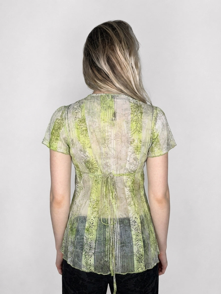 Back view of a short sleeve top in green with a floral pattern.