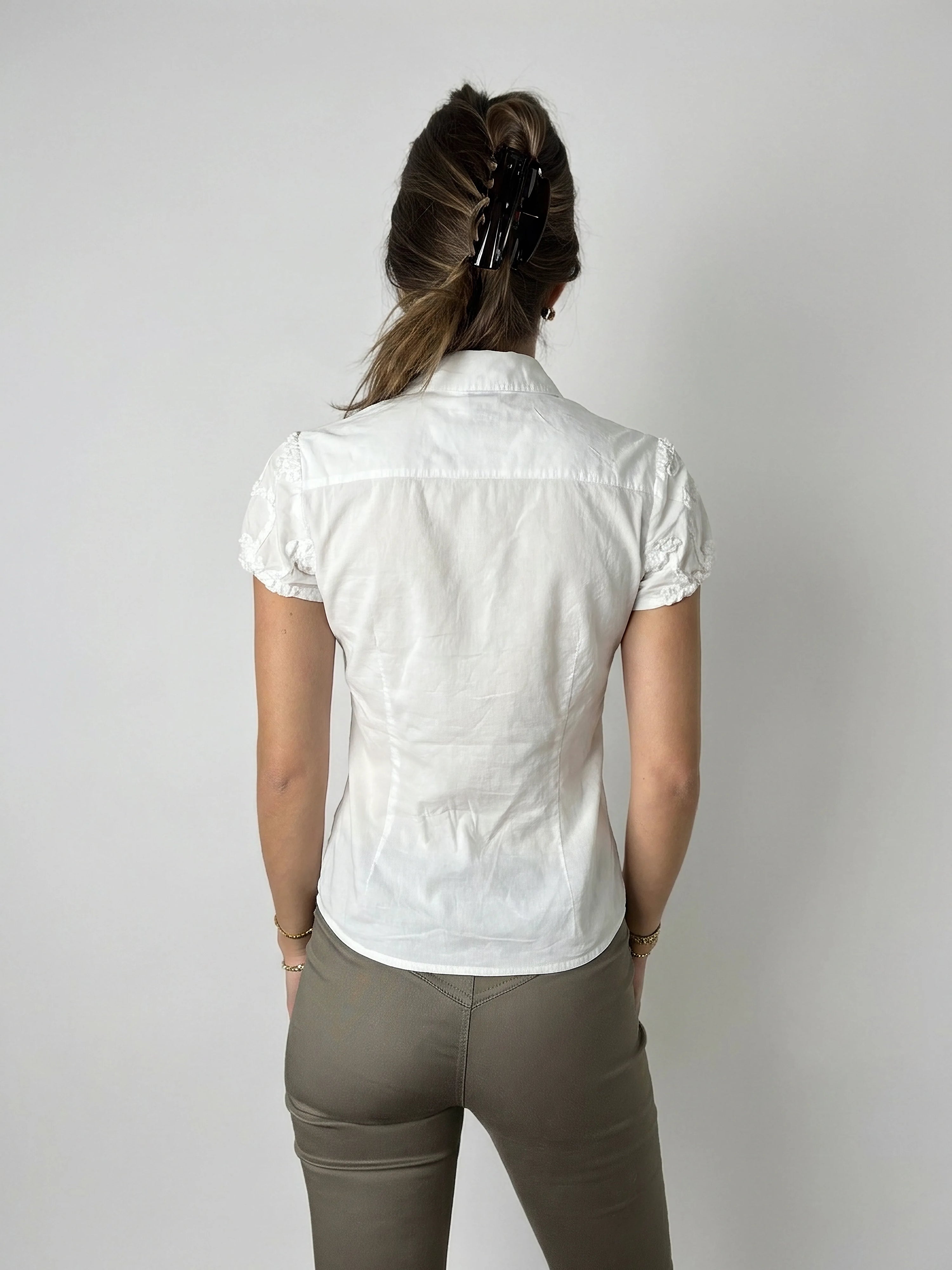 Back view of a white short sleeve top featuring delicate lace trim.