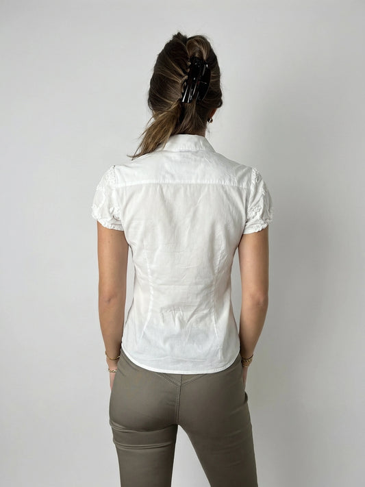 Back view of a white short sleeve top featuring delicate lace trim.