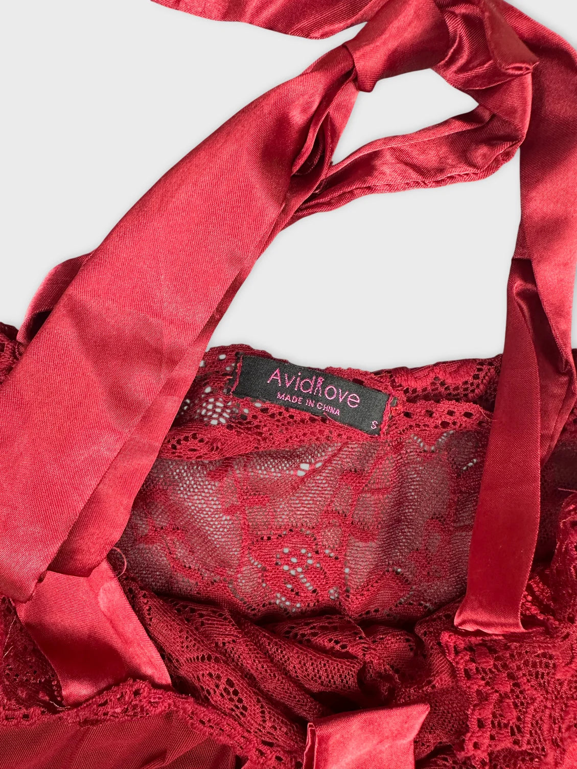 Detail view of red lace trim with satin ribbons on vintage women's shorts.