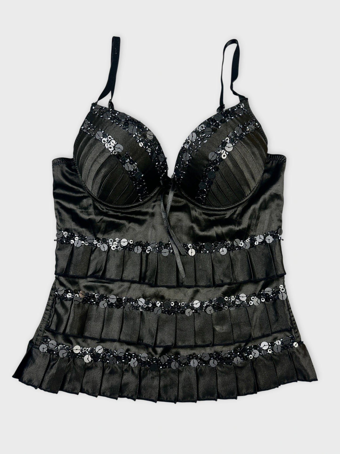 front view of a black satin top with sequined detail and ruffle trim