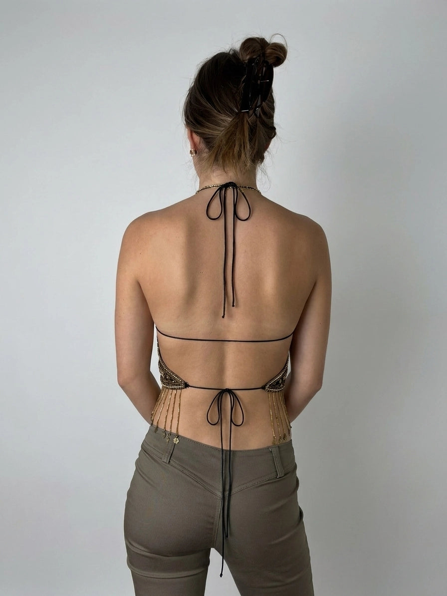 Back view of a woman wearing shorts, featuring a gold chain detail.
