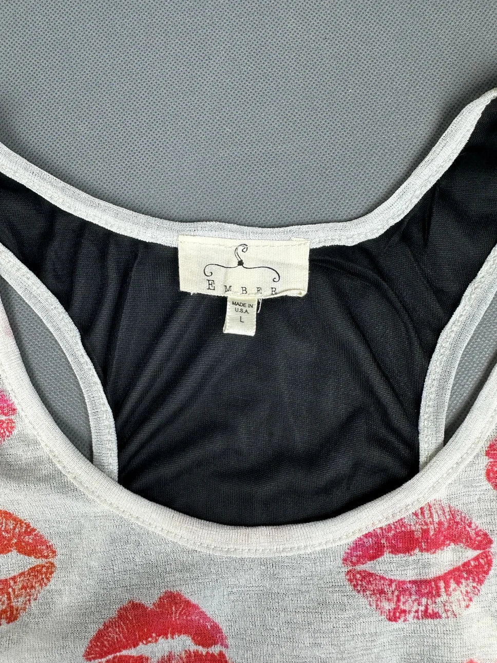 Detail view of a women's tank top featuring red lip prints.