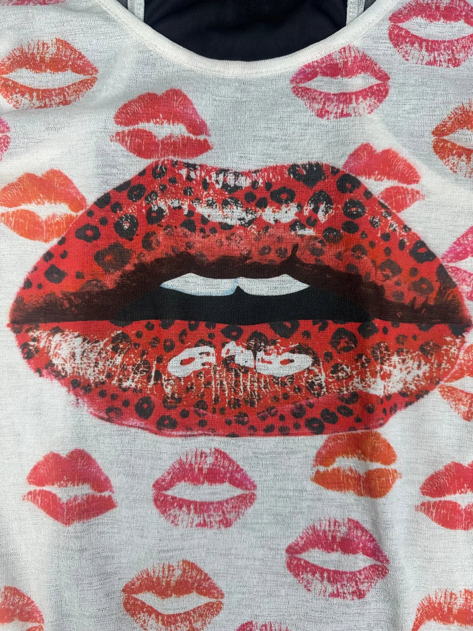 Detail view of a white tank top featuring a large red lipstick print.
