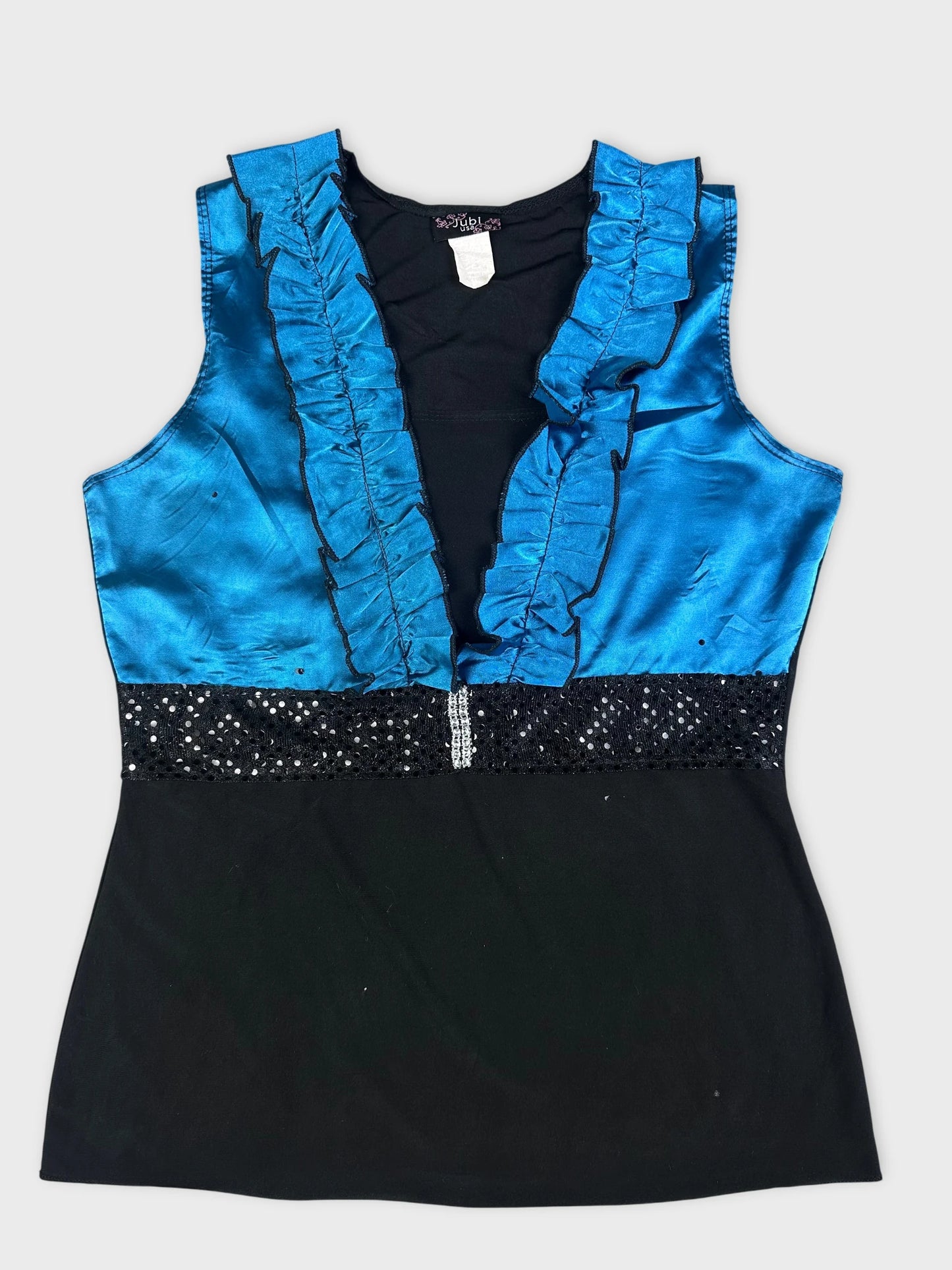 Detail view of a blue vintage top with ruffled neckline and sequin waistband.