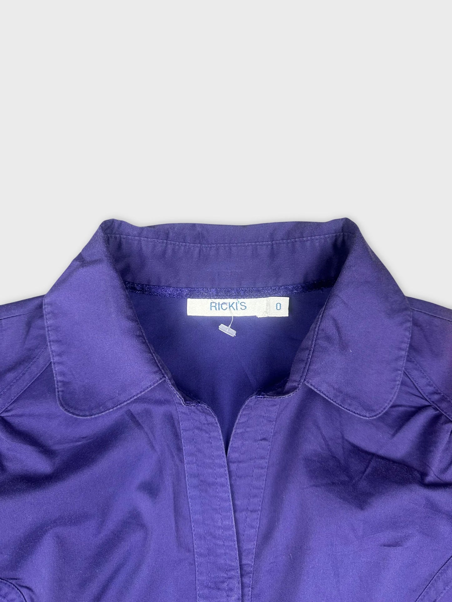 Detail view of a purple button-up shirt with a crisp collar.