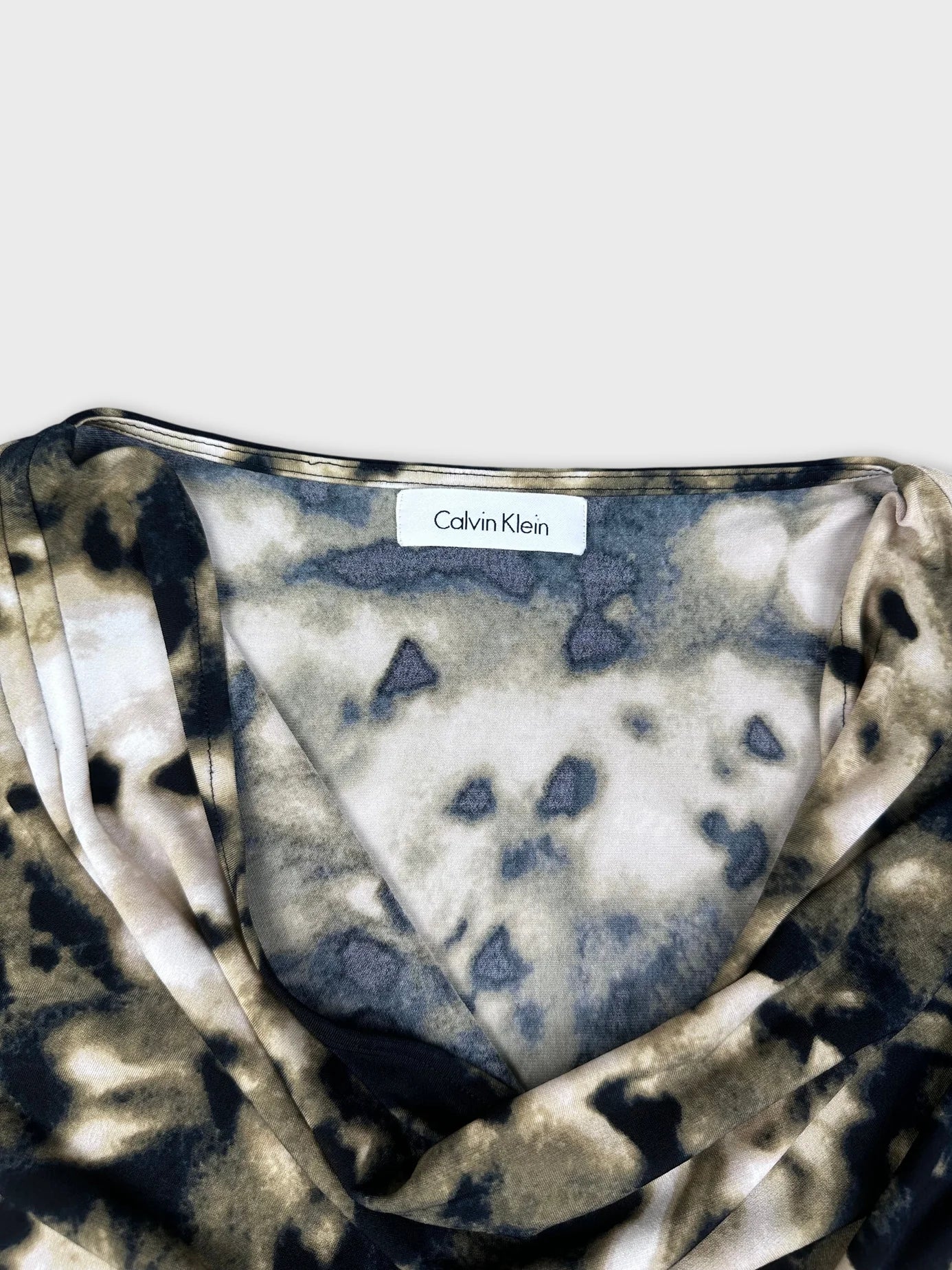 detail view of a short sleeve top in beige and black tie-dye pattern