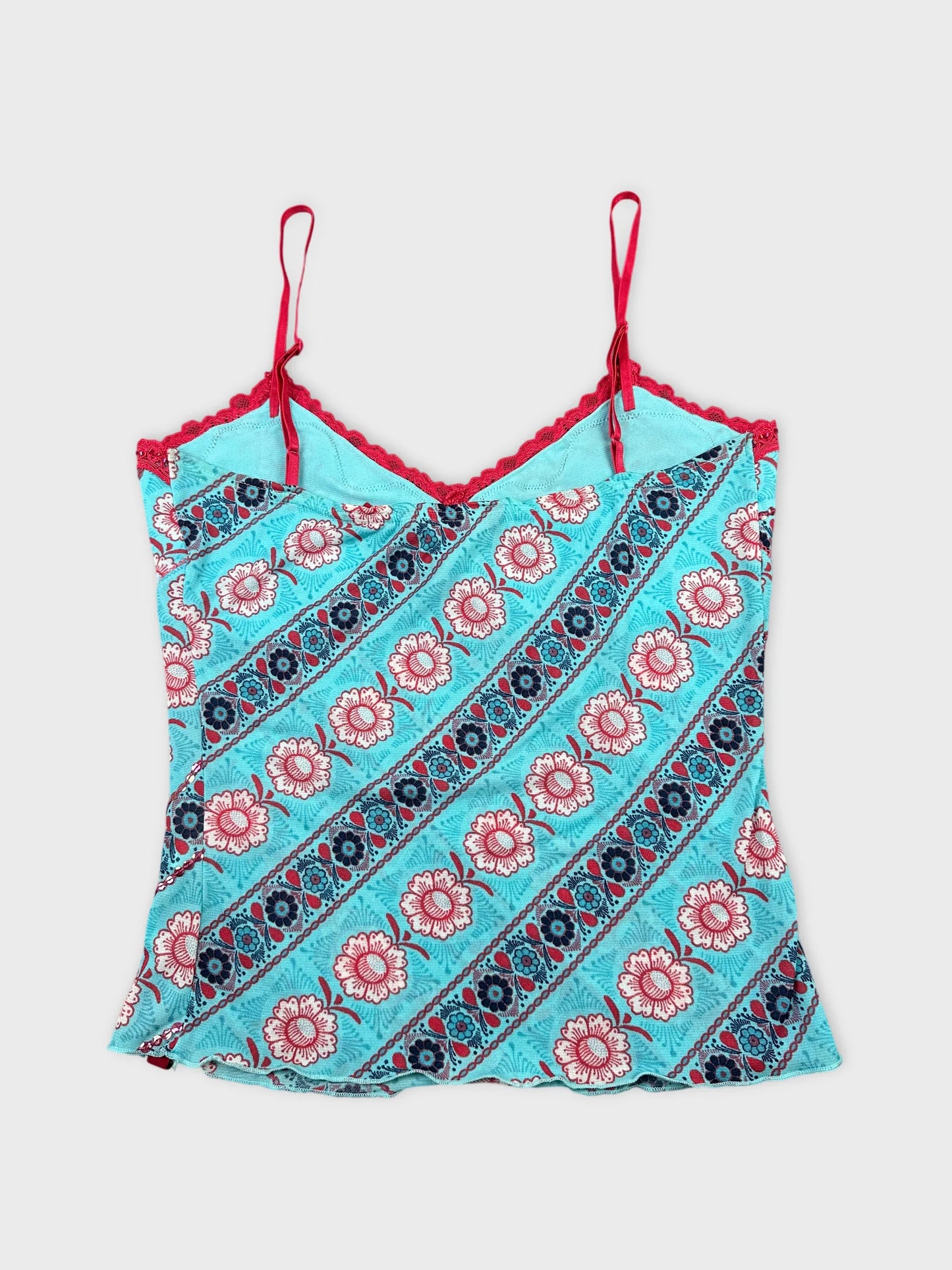 Back view of a turquoise floral spaghetti strap top with red trim.