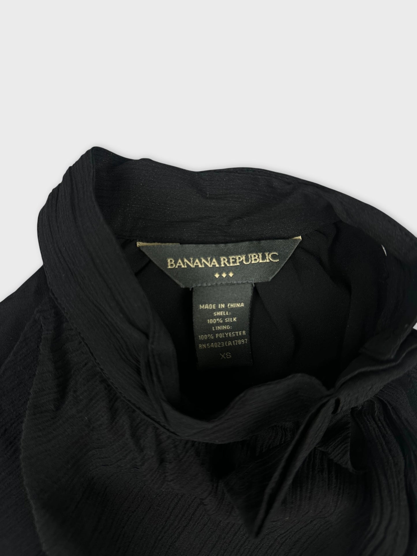detail view of black upper body shorts featuring a textured fabric and collar
