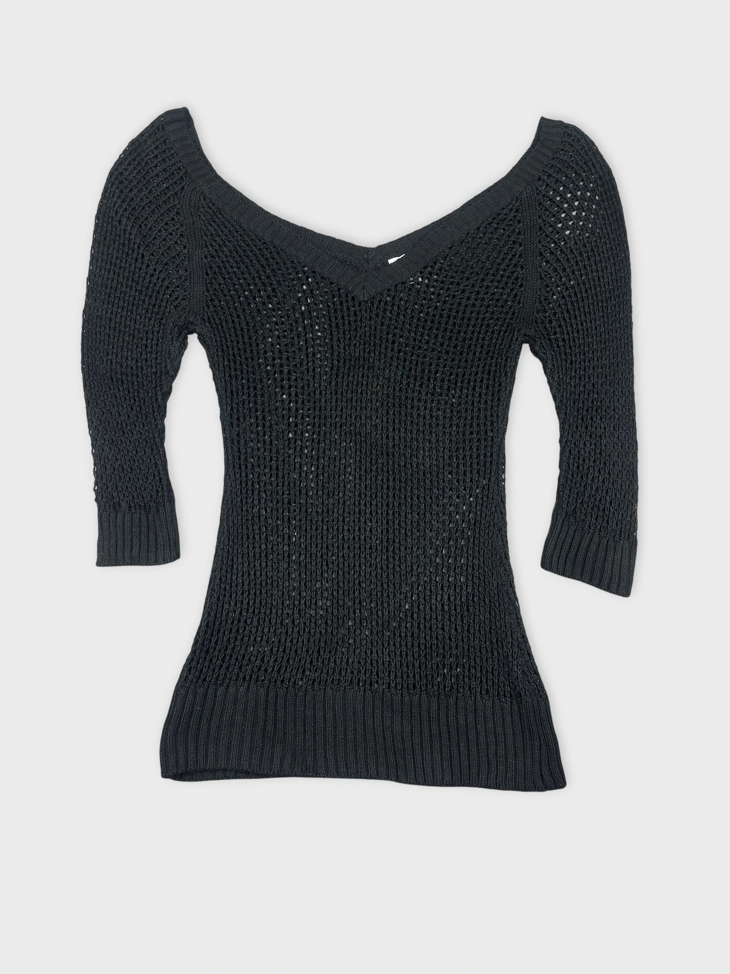 Black knit top with a v-neck and ribbed hem front view