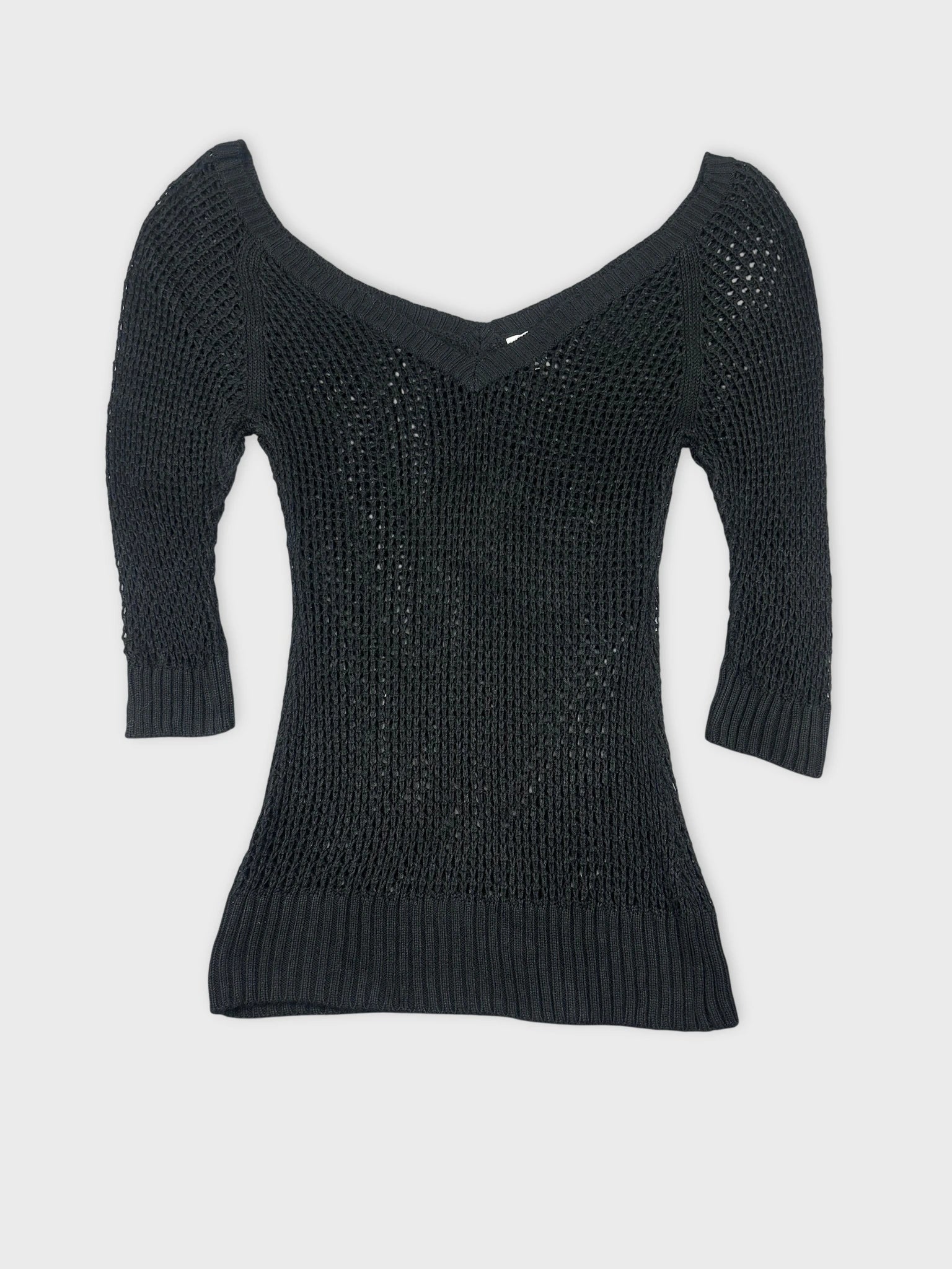 Black knit top with a v-neck and ribbed hem front view
