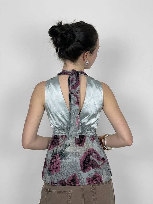 Back view of a vintage women's halter top in light blue with floral print.