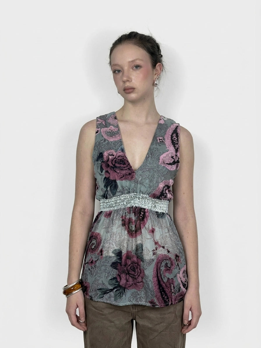 Front view of a vintage sleeveless top in gray with floral print and gathered waist.