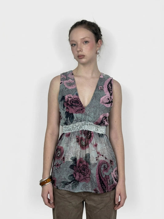 Front view of a vintage sleeveless top in gray with floral print and gathered waist.