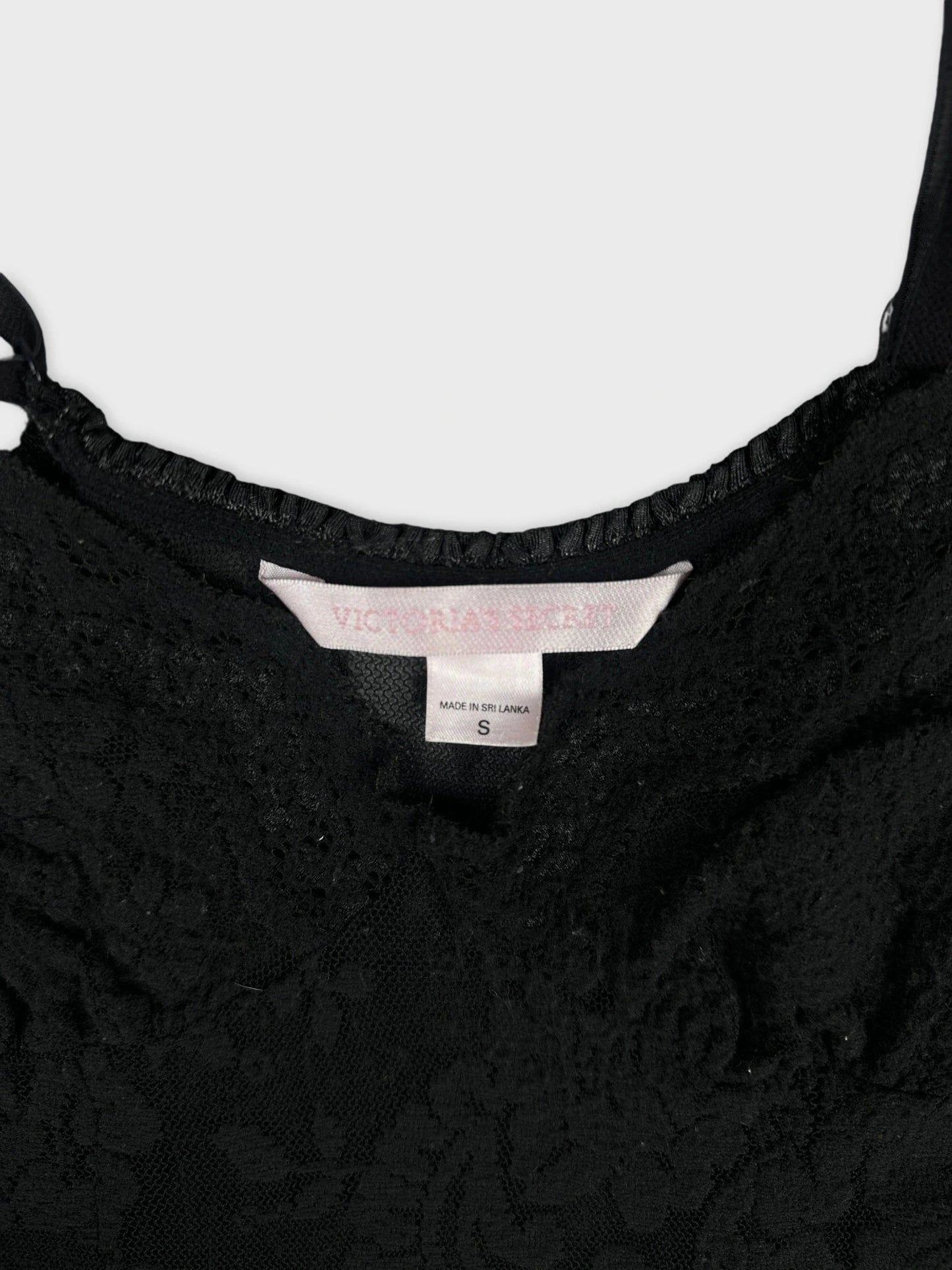 Detail view of a black lace upper body top highlighting intricate floral patterns.