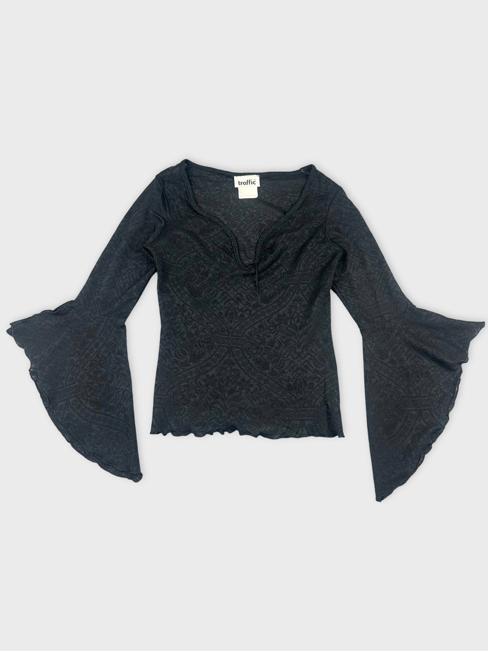 Front view of a black long sleeve top with bell sleeves and textured pattern.