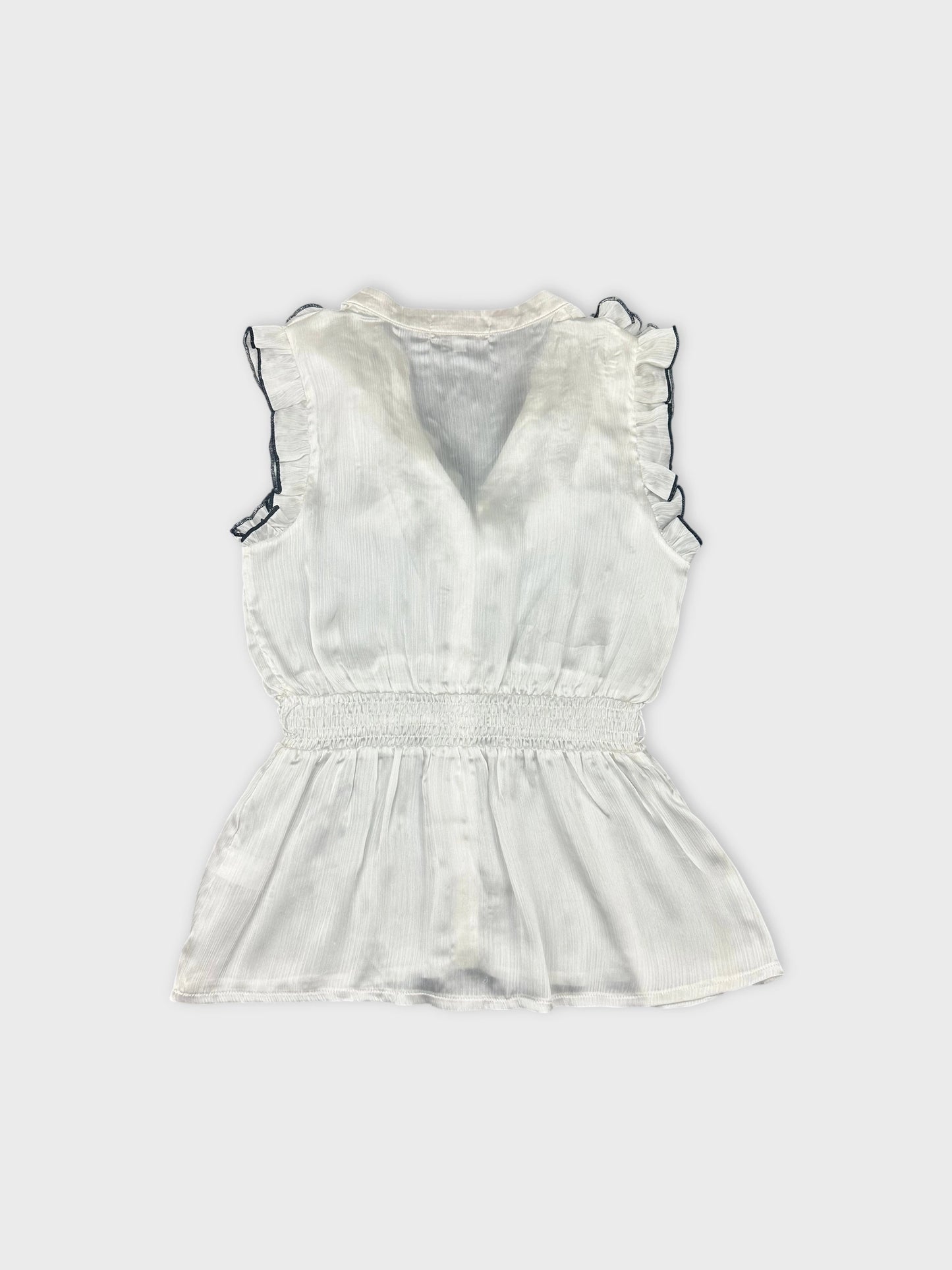 Back view of a white vintage top with frill details and smocked waist.