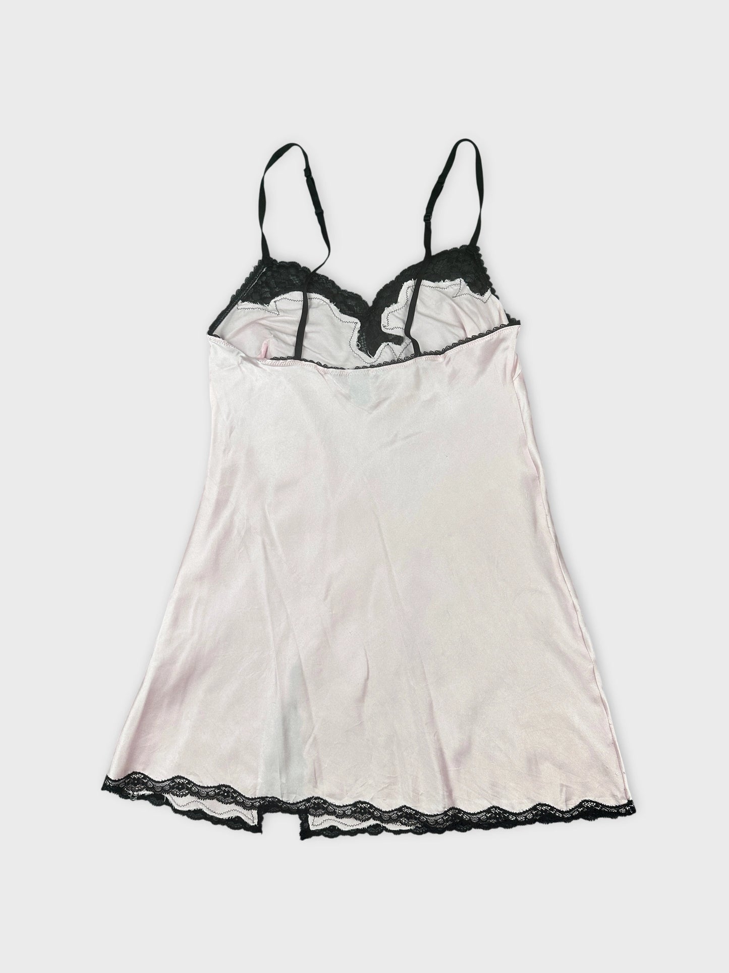 Back view of a pink vintage top with black lace trim.