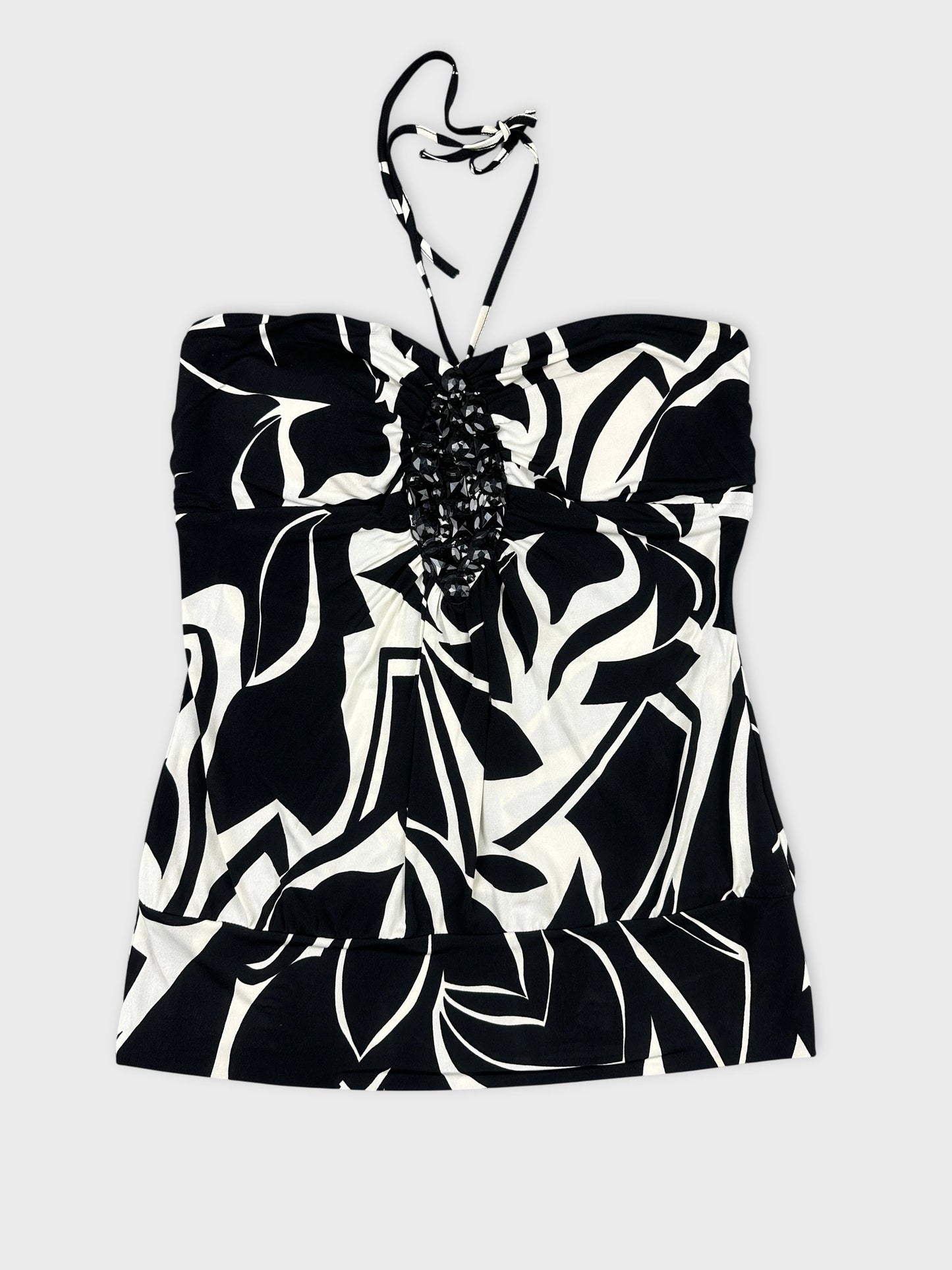 Back view of a black and white patterned strapless top with decorative trim.