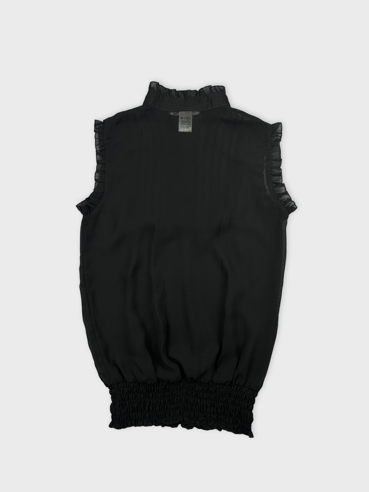 Back view of a black women's top with ruffled arm trim.
