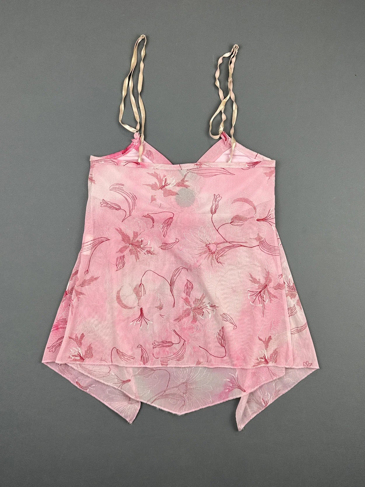 Back view of a pink floral print women’s top with adjustable straps.