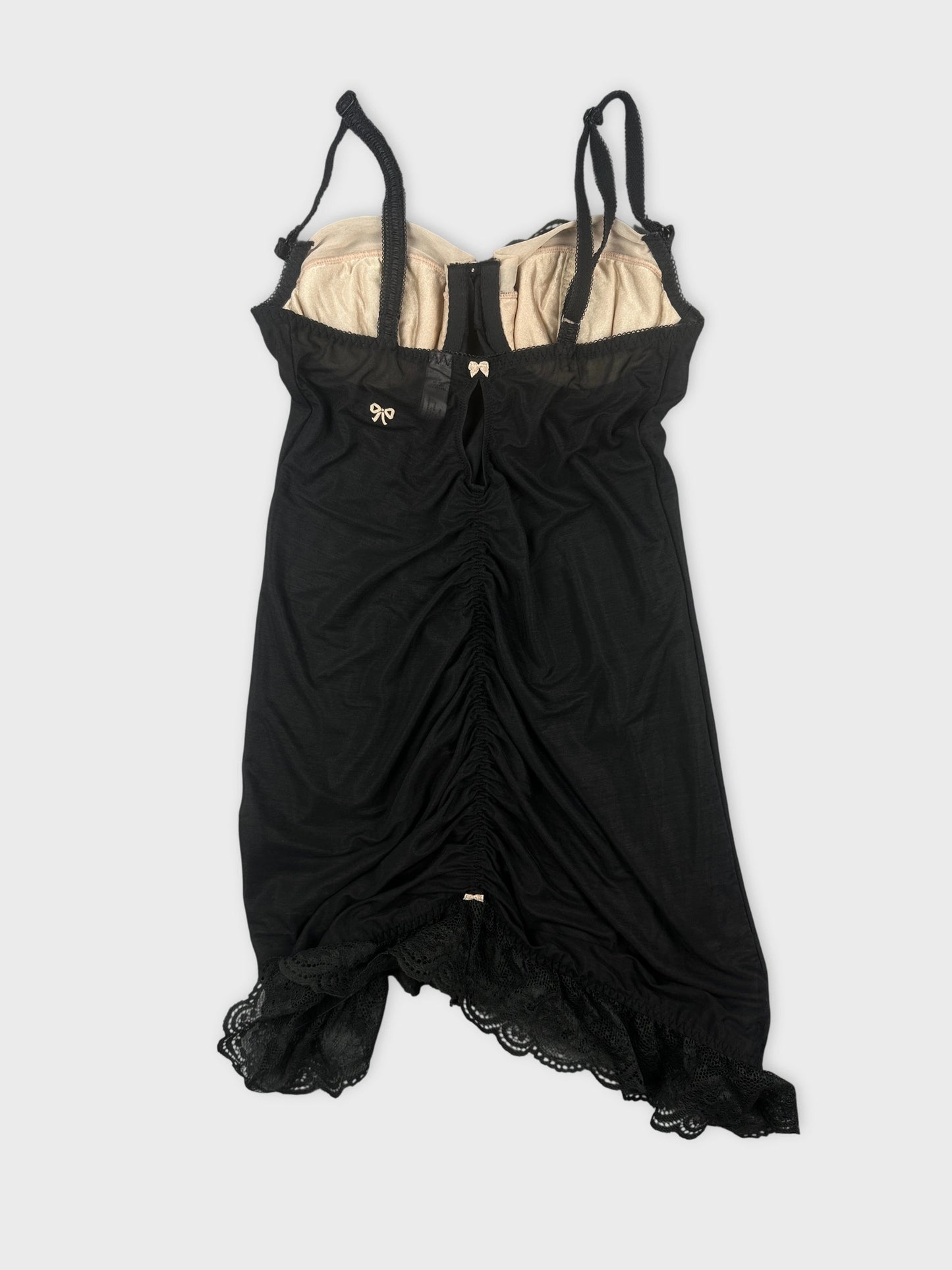 Back view of a black vintage top featuring lace trim and adjustable straps.