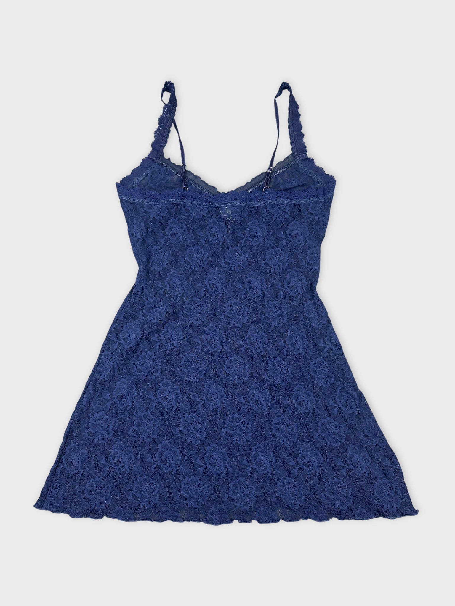 Back view of a women's navy lace top featuring floral pattern and adjustable straps.