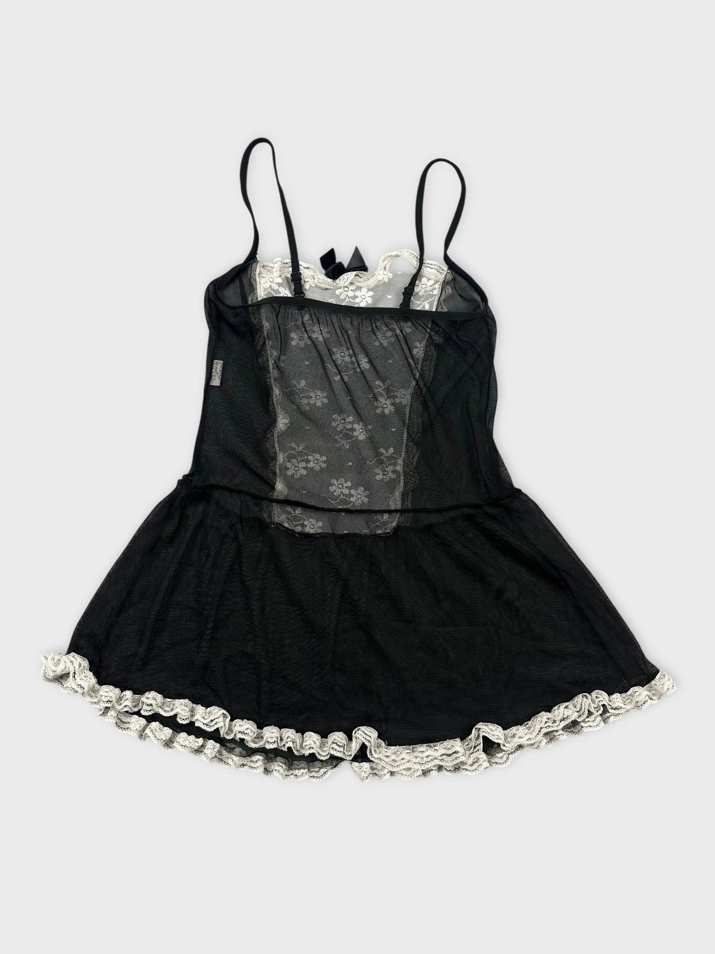 Back view of a black vintage top with lace trim and floral pattern.