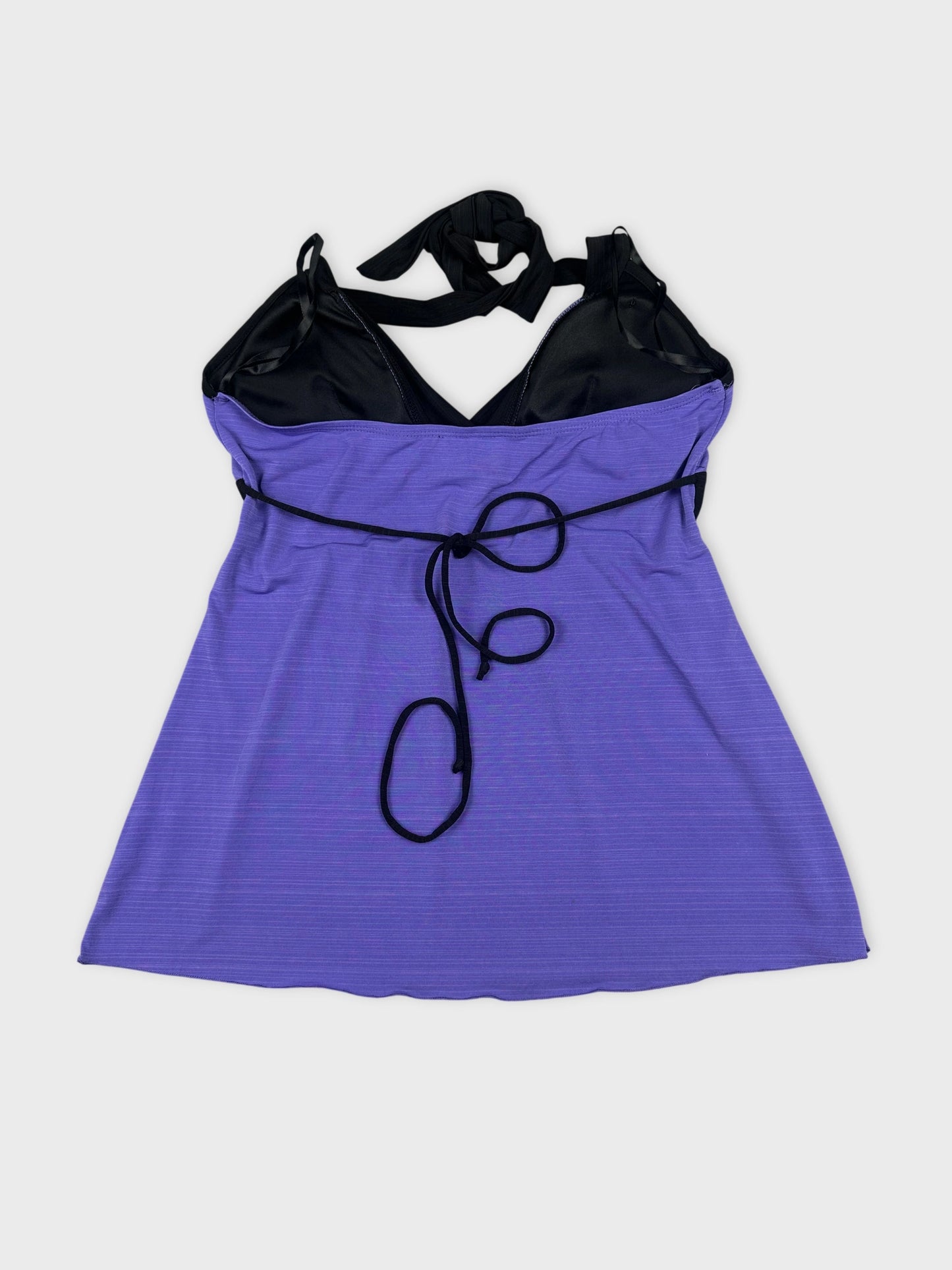 Back view of a purple sleeveless top with black straps and tie detail.