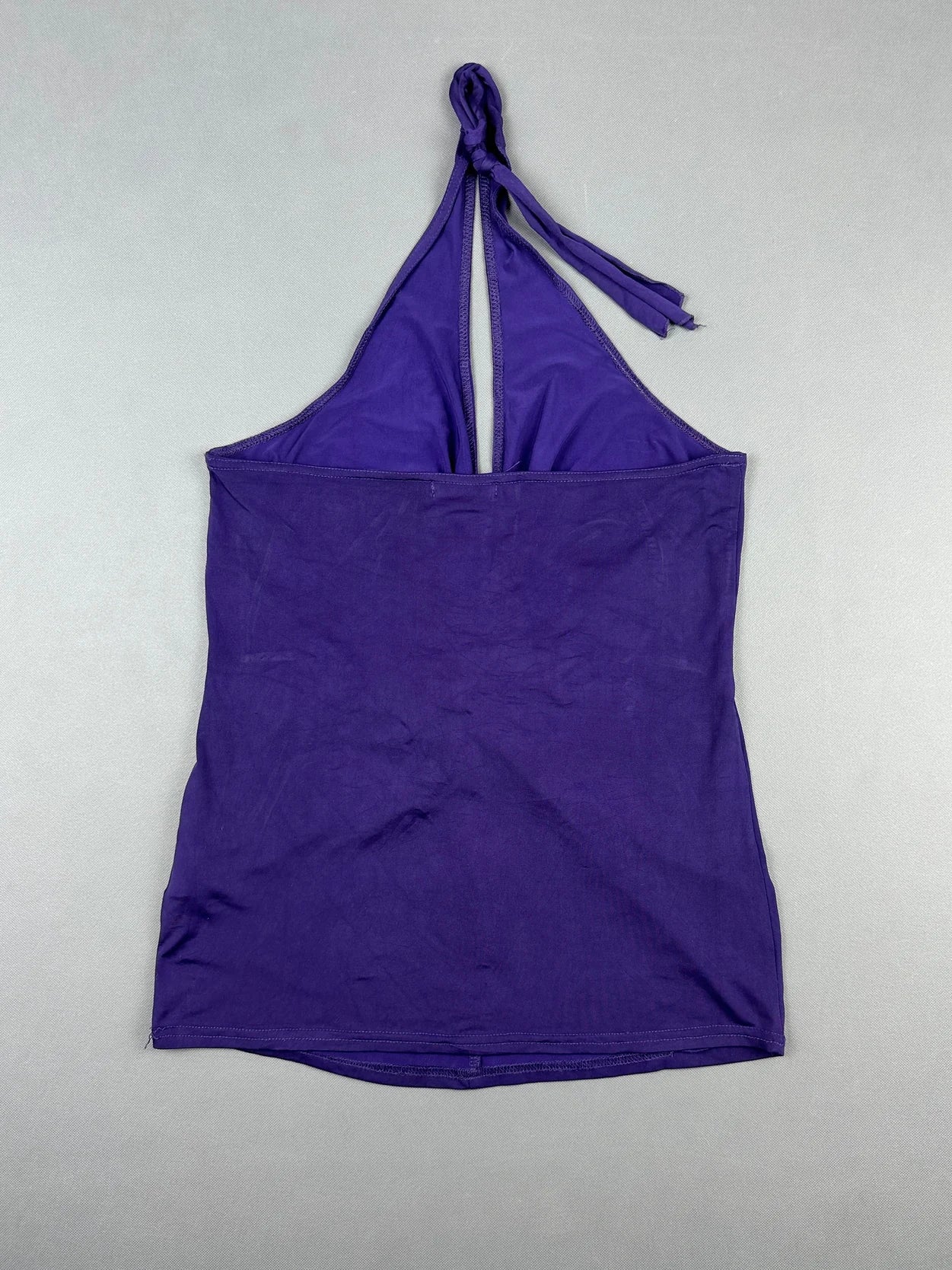 Back view of a purple halter top featuring a knotted tie detail