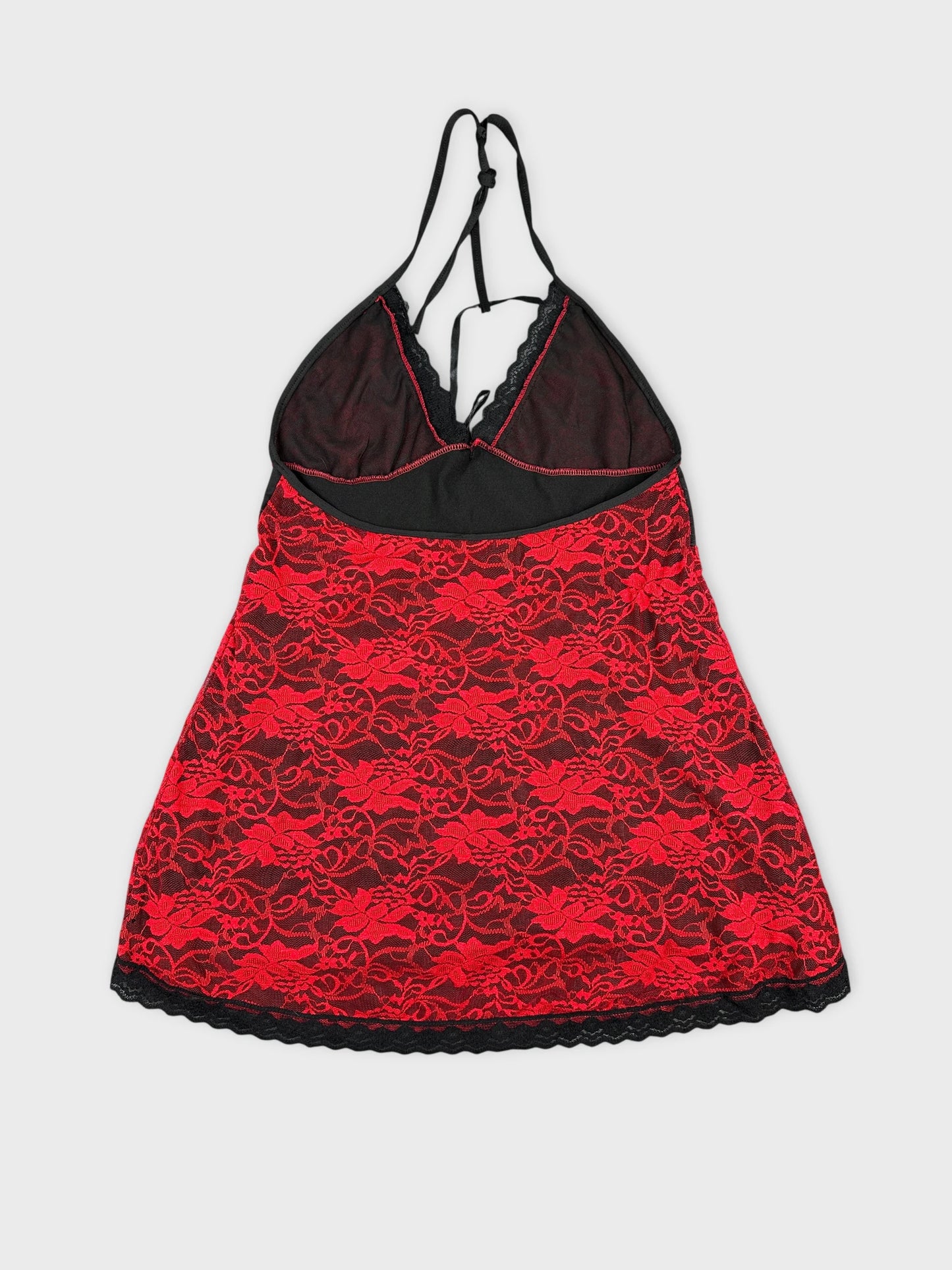 Back view of a red lace halter top with black trim.