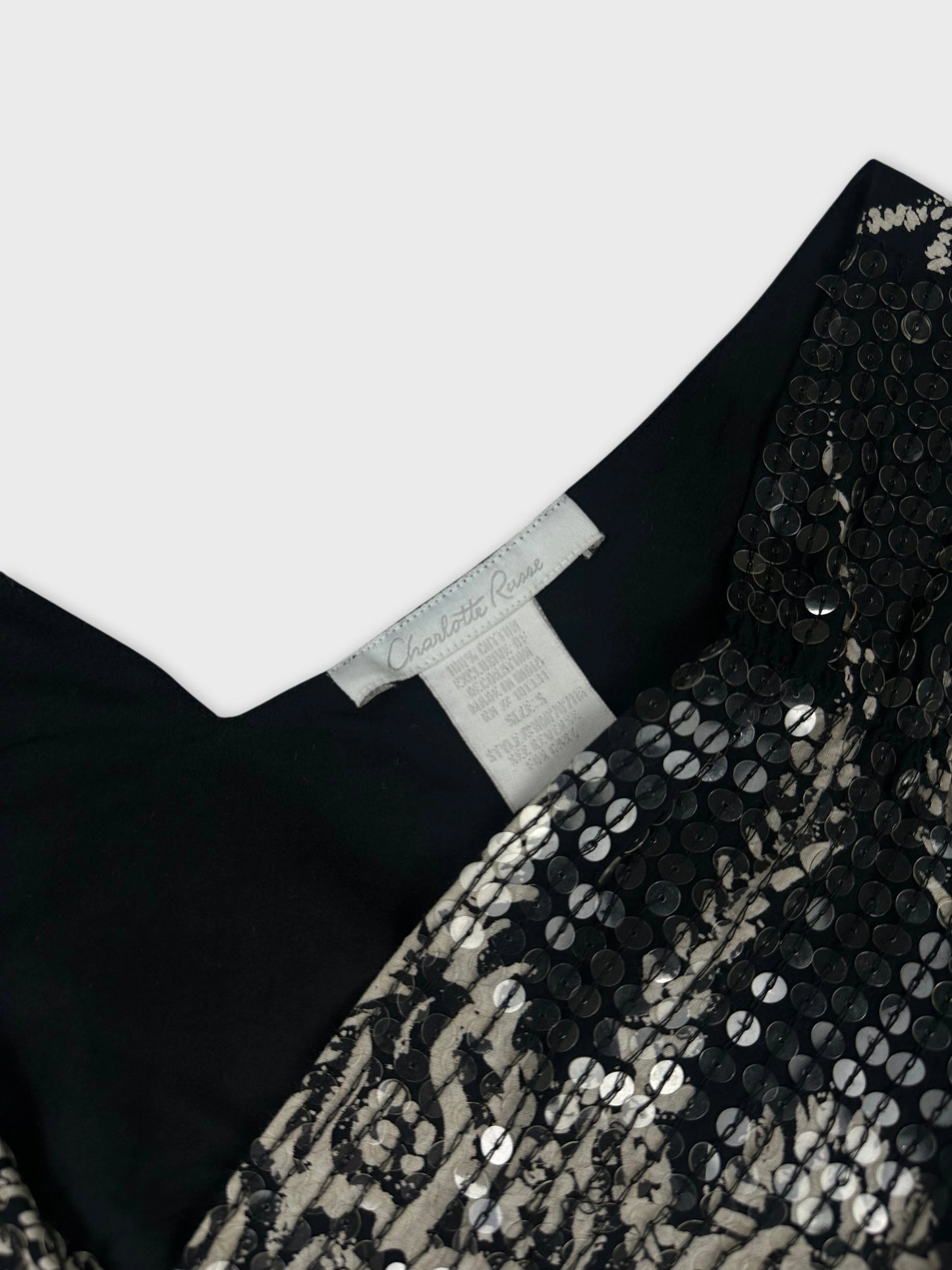 Detail view of black vintage top with sequined floral pattern.