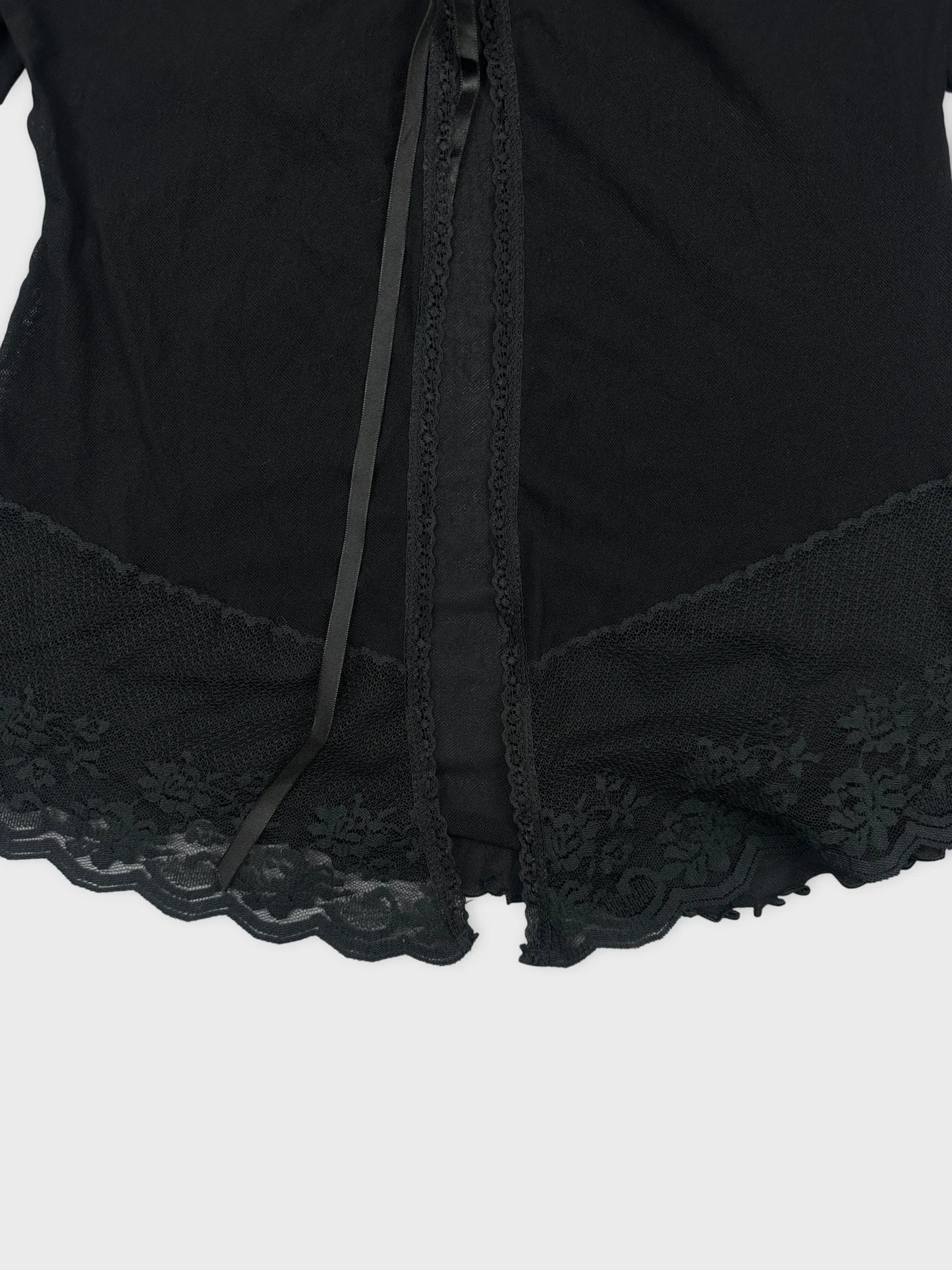 detail view of a black vintage upper body top with lace trim