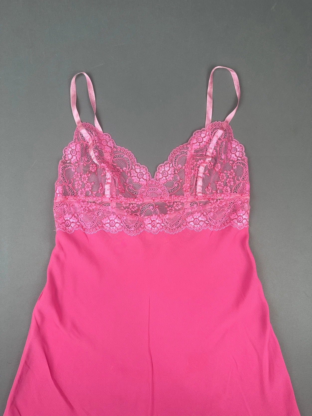 Detail view of a pink lace-trimmed camisole top with adjustable straps.