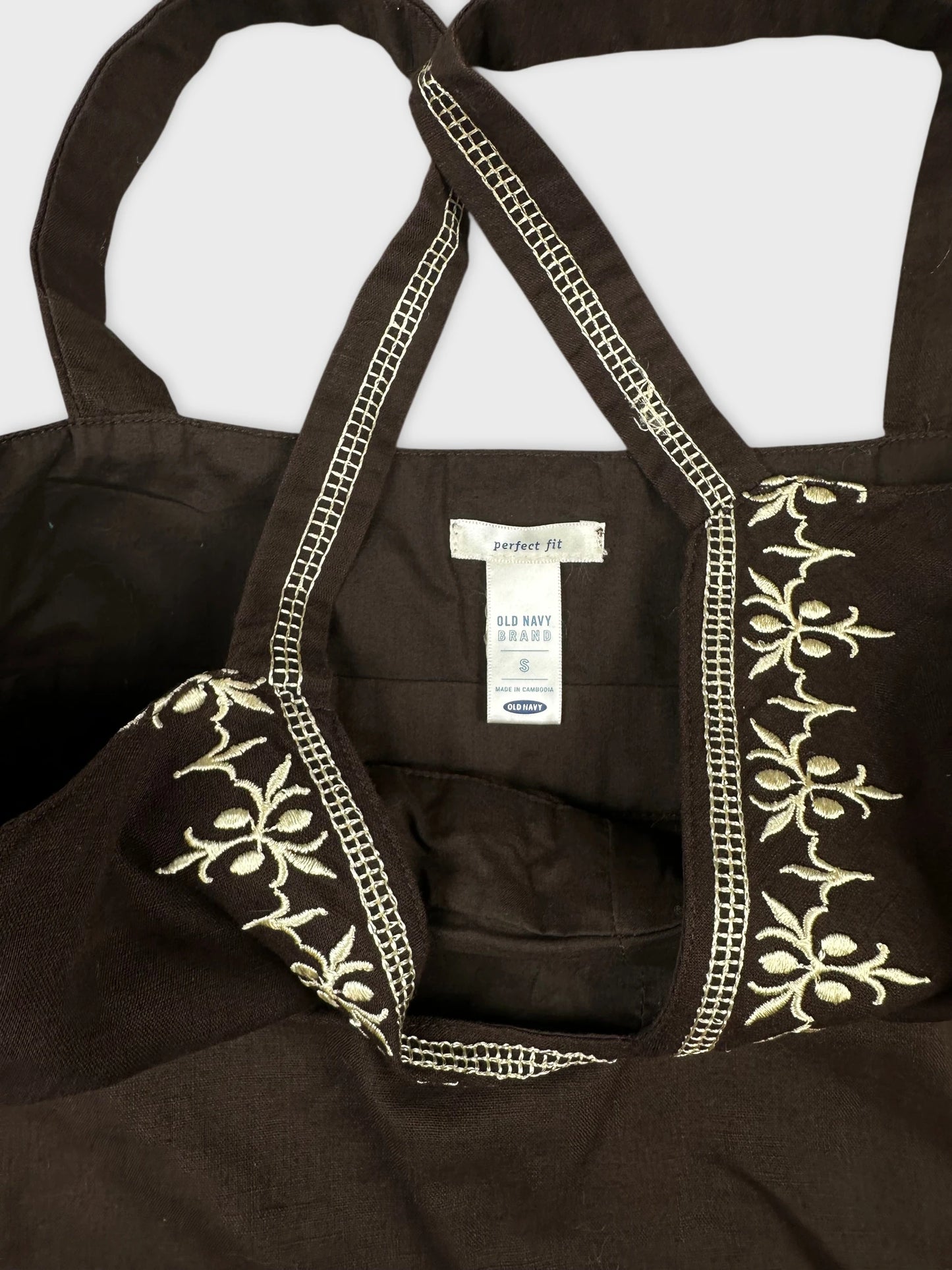 Detail view of a brown women's top featuring floral embroidery.