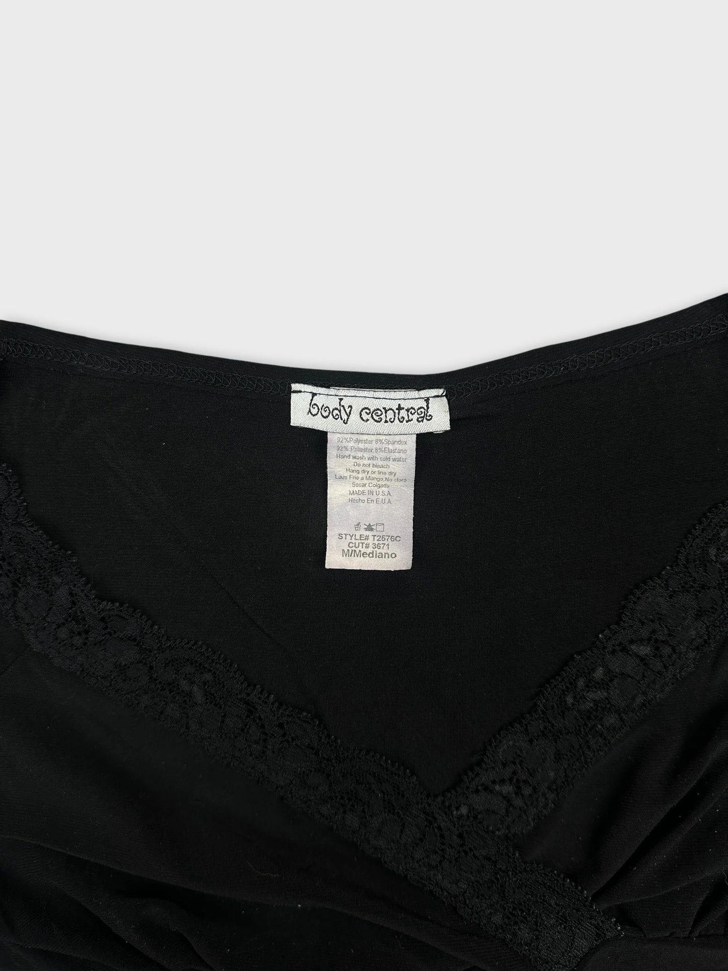 Detail view of a black women's top featuring lace trim.