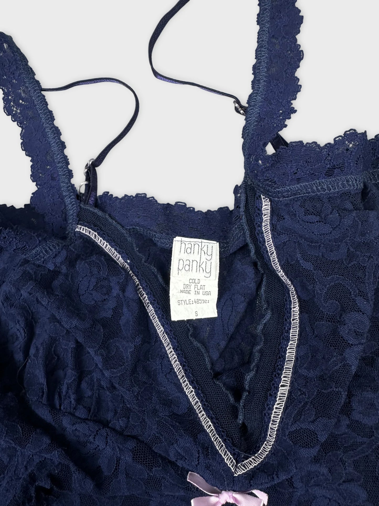 Navy lace top detail view featuring a delicate pink bow.