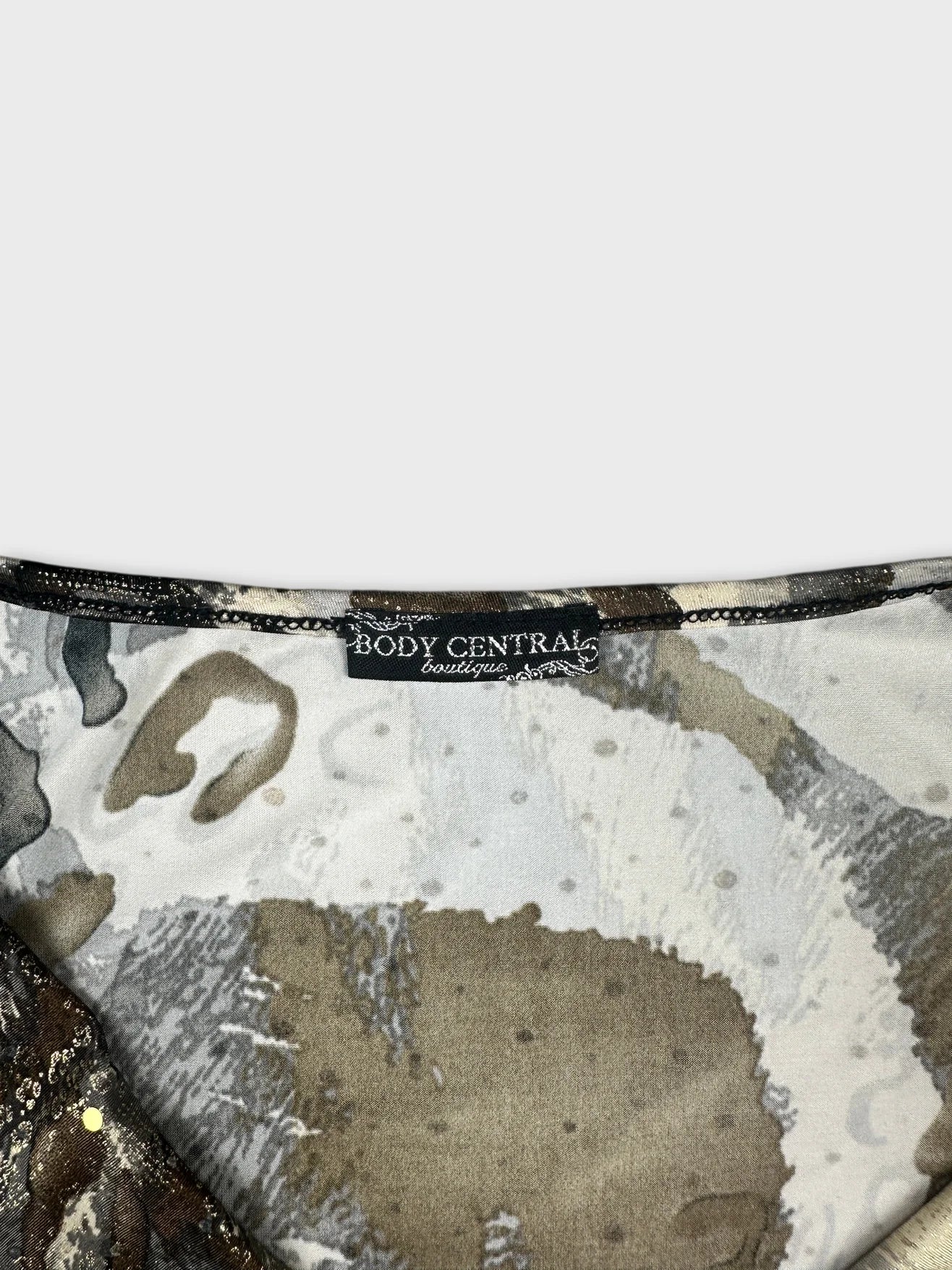 Detail view of a women’s top featuring earthy tones and abstract patterns.