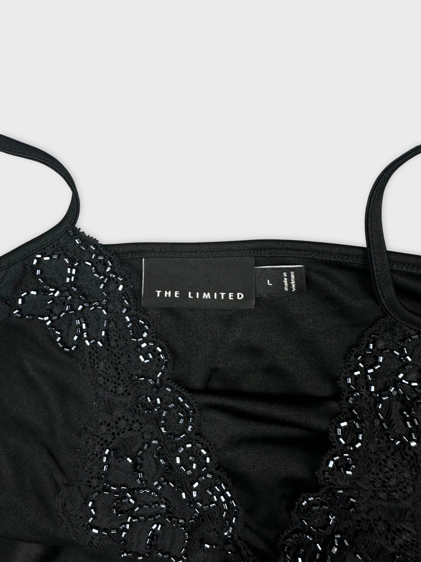 Detail view of a black upper body top with lace trim