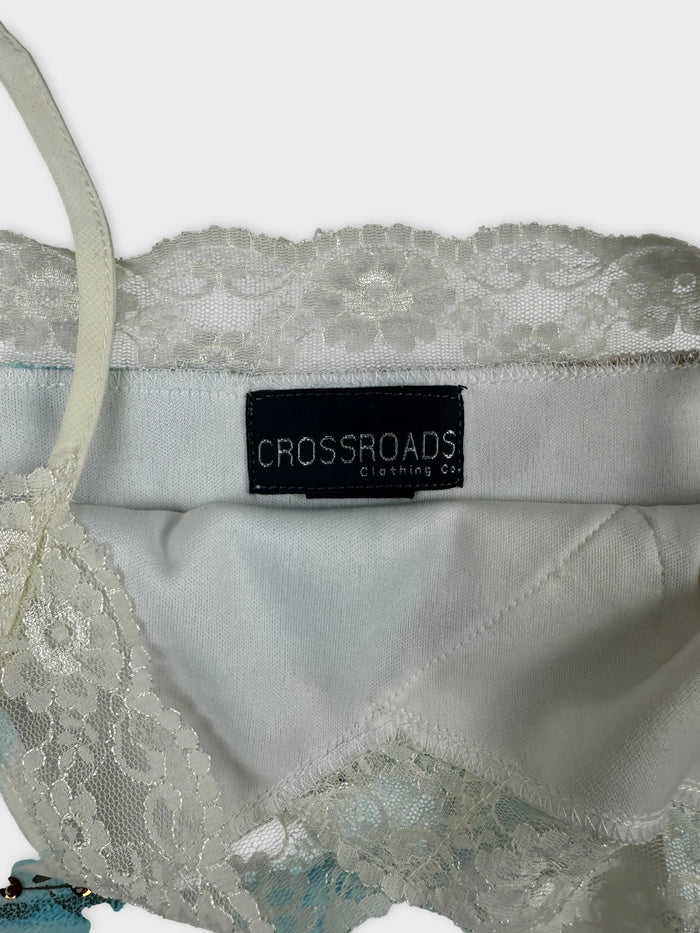 Detail view of a light blue upper body top featuring lace trim.