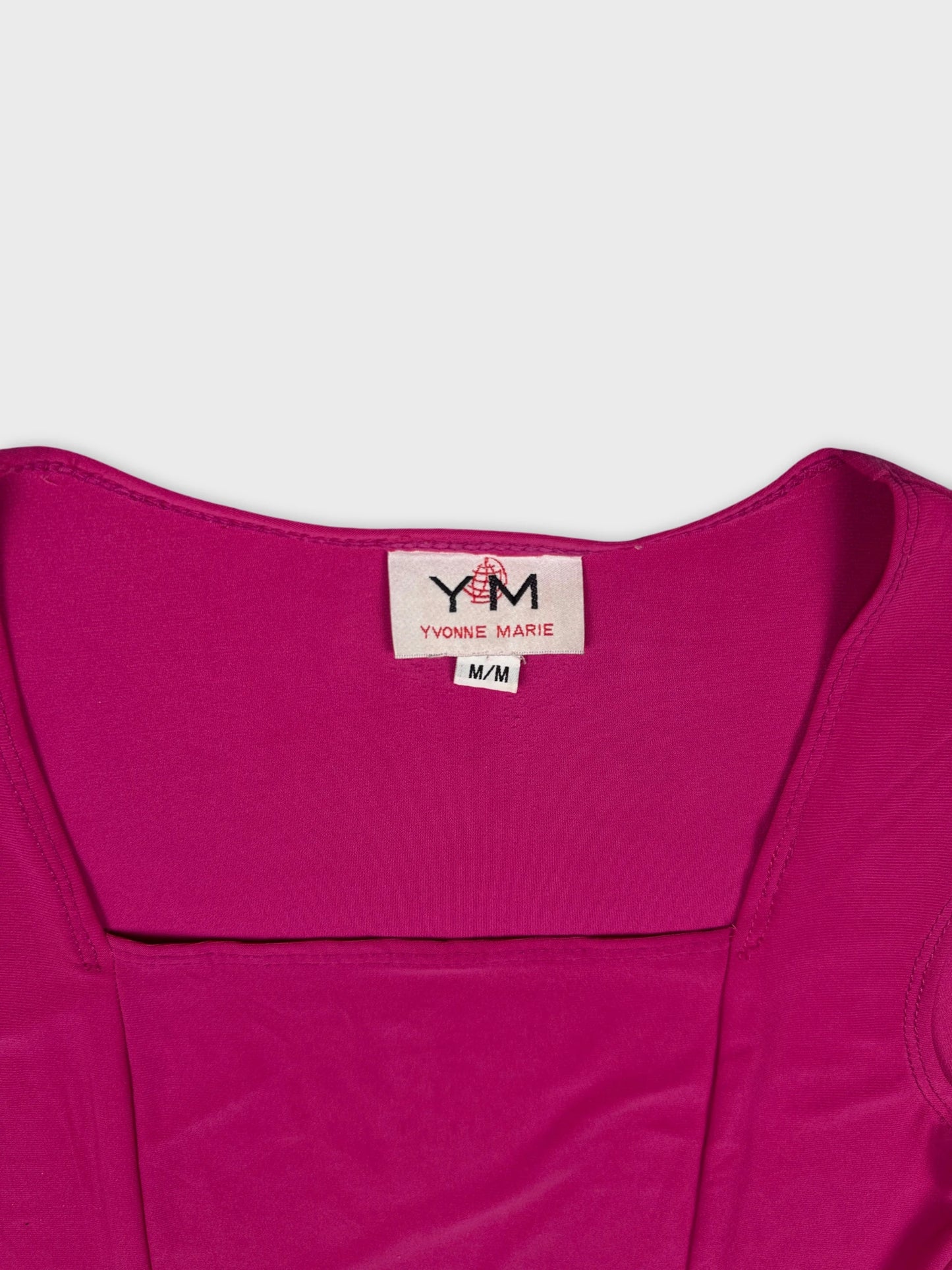 Detail view of a pink women's top featuring a scoop neckline.