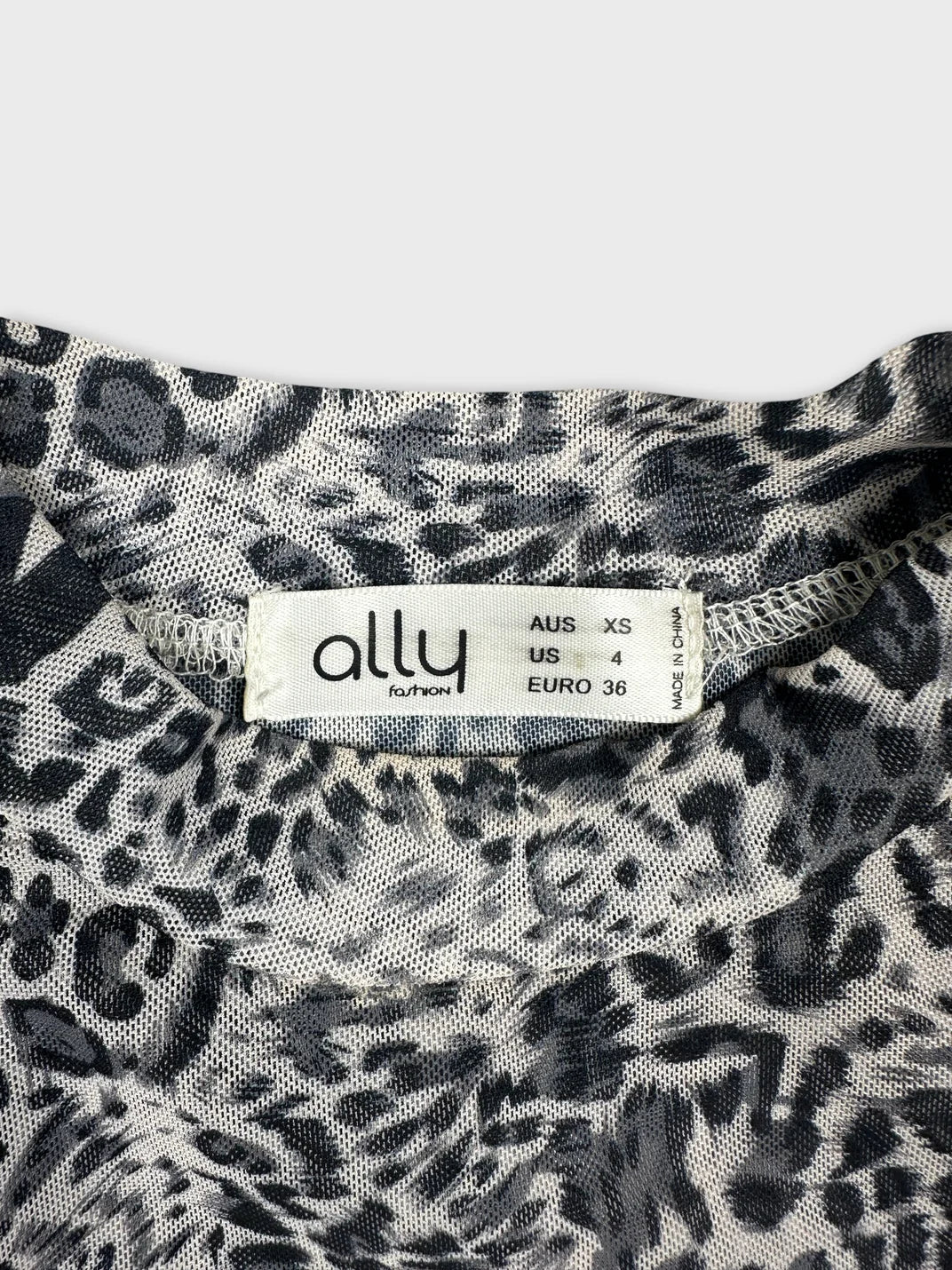 Detail view of a women's top in black and white animal print.